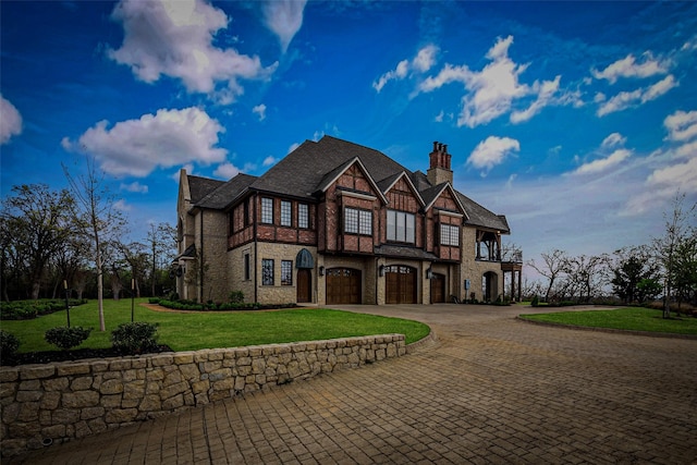 3801 Dugas Rd, Aubrey, TX 76227 - tudor home featuring a chimney, a front yard, a garage, curved driveway, and stone siding