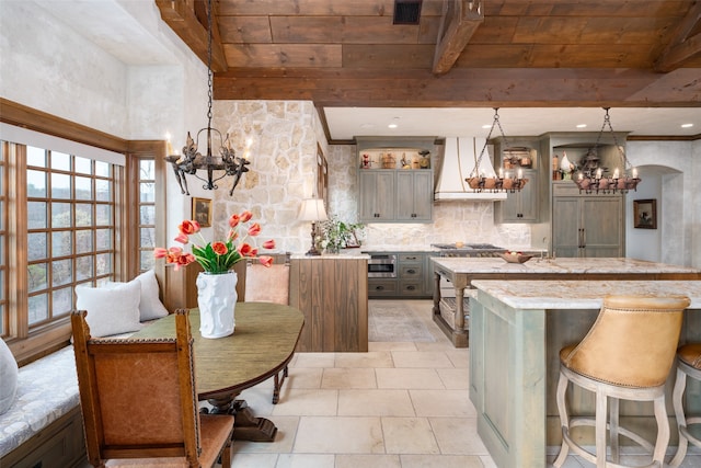 kitchen featuring pendant lighting, premium range hood, beam ceiling, a kitchen island, and appliances with stainless steel finishes