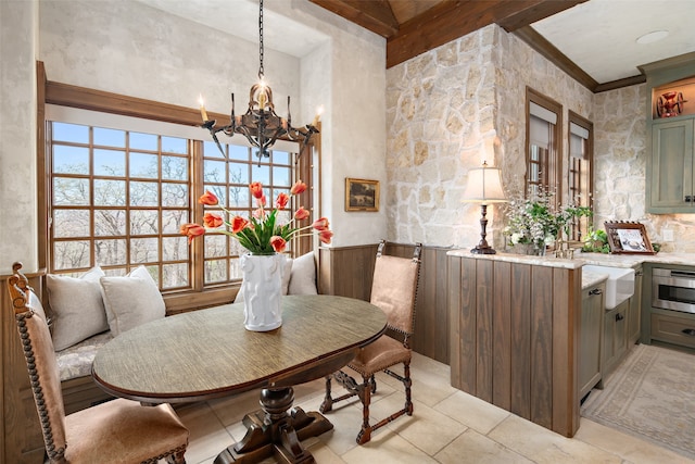 dining area with beam ceiling, a notable chandelier, and sink