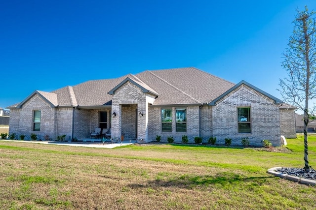 french country inspired facade with a front yard and a patio