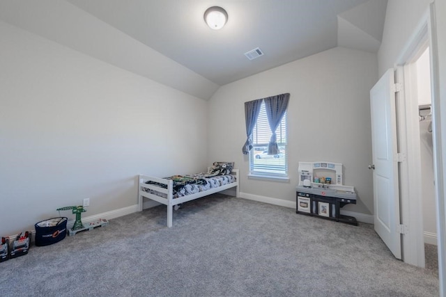 bedroom featuring light colored carpet and vaulted ceiling