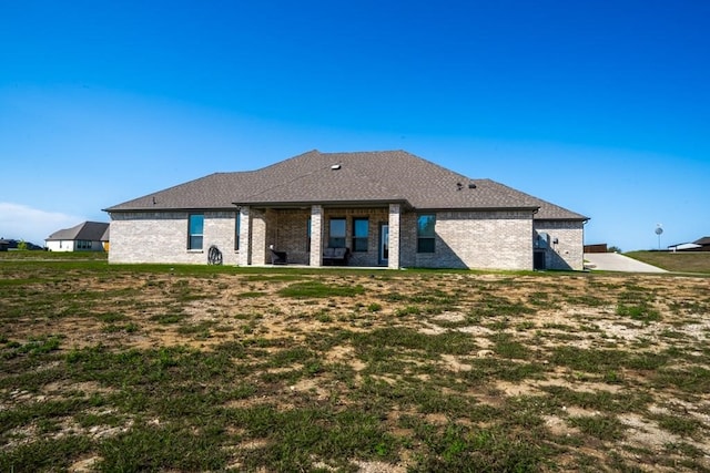 rear view of house with a yard and a patio