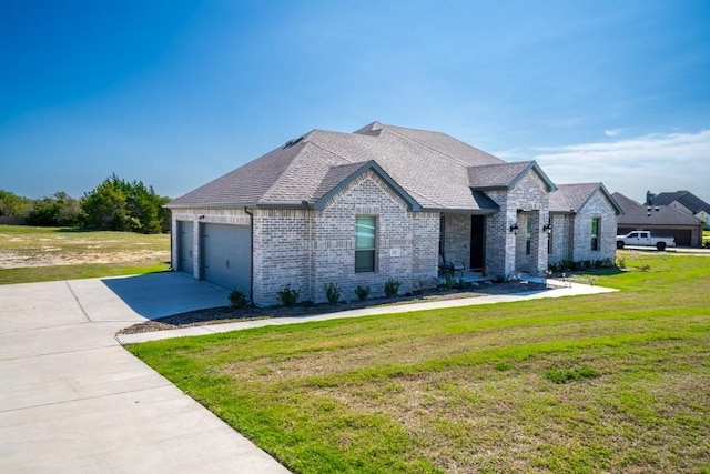 french provincial home featuring a front yard and a garage