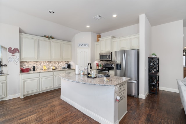 kitchen featuring a kitchen island with sink, tasteful backsplash, dark hardwood / wood-style flooring, light stone countertops, and appliances with stainless steel finishes