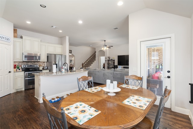 dining area with dark wood-type flooring, vaulted ceiling, sink, and ceiling fan