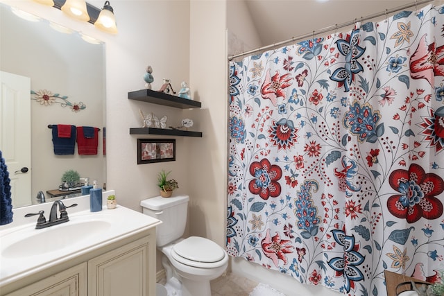 bathroom with toilet, curtained shower, tile patterned floors, lofted ceiling, and vanity