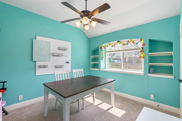 unfurnished office with light carpet, ceiling fan, and vaulted ceiling