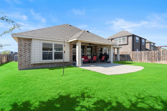 back of house featuring ceiling fan, a patio, and a lawn