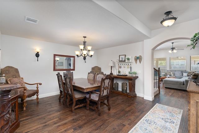 dining space with ceiling fan with notable chandelier and dark hardwood / wood-style flooring