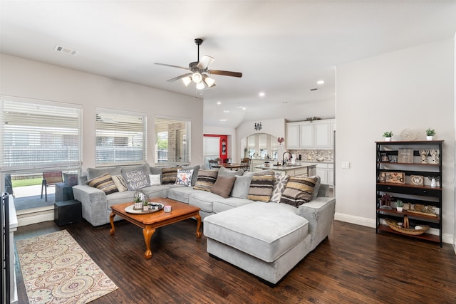 living room with dark wood-type flooring, ceiling fan, and a healthy amount of sunlight