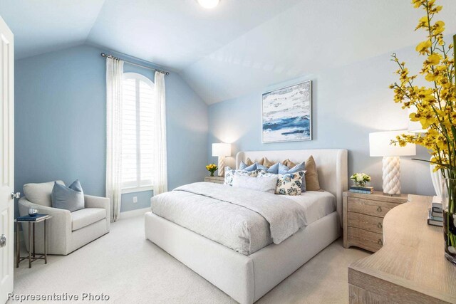 bedroom featuring lofted ceiling and light carpet