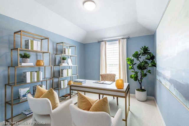 carpeted home office featuring lofted ceiling