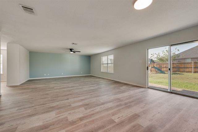 spare room featuring light hardwood / wood-style floors, a wealth of natural light, and ceiling fan