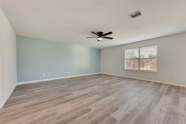 spare room with light wood-type flooring and ceiling fan