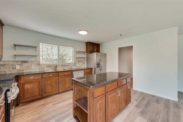 kitchen with stainless steel appliances, light hardwood / wood-style flooring, sink, and a center island