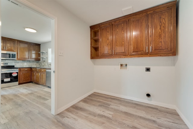 clothes washing area with washer hookup, light wood-type flooring, and hookup for an electric dryer