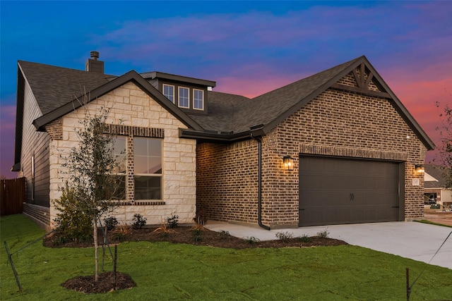 view of front of home featuring a garage and a lawn