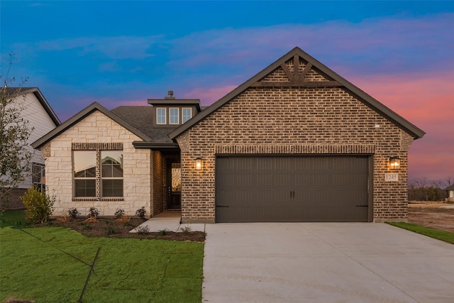 view of front of property with a garage and a yard