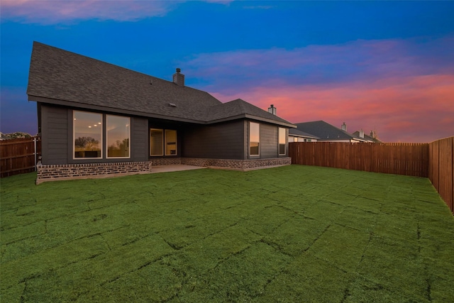 back house at dusk with a yard