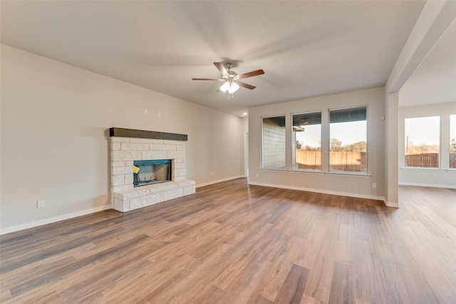 unfurnished living room with ceiling fan, hardwood / wood-style flooring, and a fireplace