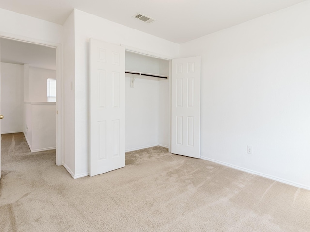 unfurnished bedroom with baseboards, visible vents, carpet, and a closet