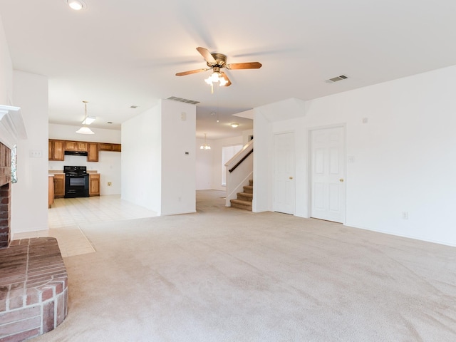 unfurnished living room with ceiling fan, visible vents, stairs, and light colored carpet