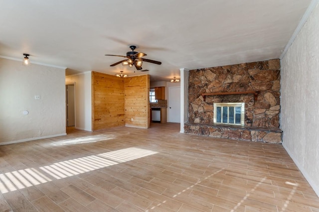 unfurnished living room with ceiling fan, light hardwood / wood-style floors, crown molding, and a fireplace