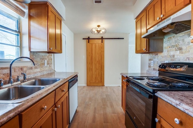 kitchen with black range with electric stovetop, sink, light wood-type flooring, stainless steel dishwasher, and a barn door