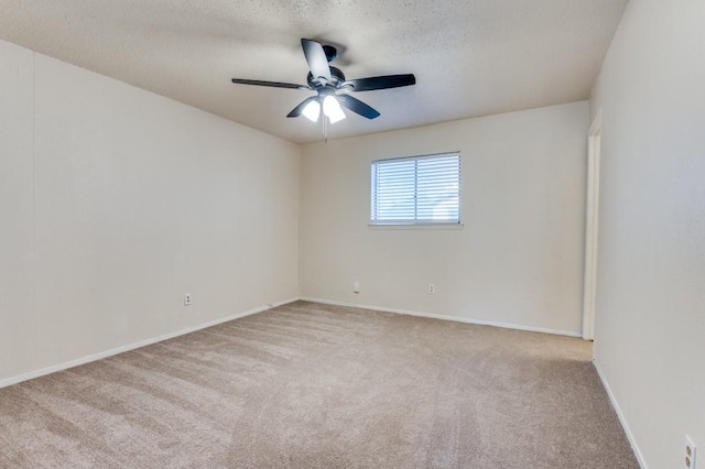 spare room with ceiling fan, light colored carpet, and a textured ceiling