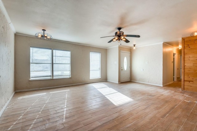 unfurnished room with ceiling fan with notable chandelier, crown molding, and light wood-type flooring