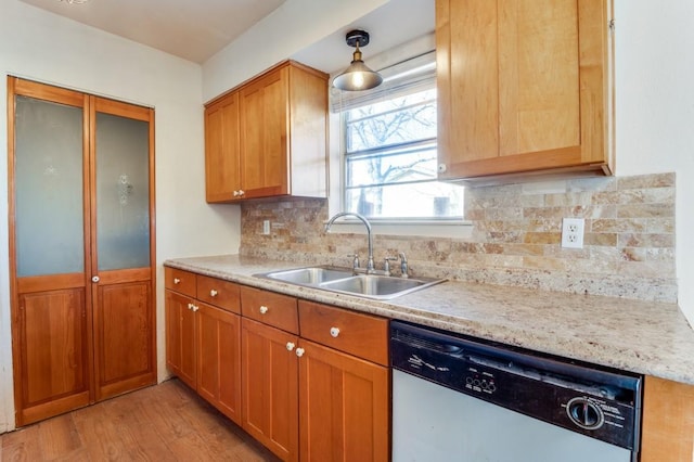 kitchen with backsplash, pendant lighting, stainless steel dishwasher, light hardwood / wood-style flooring, and sink