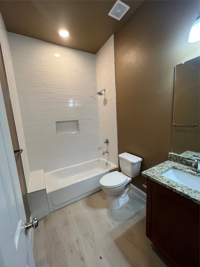 full bathroom featuring toilet, vanity, and tiled shower / bath