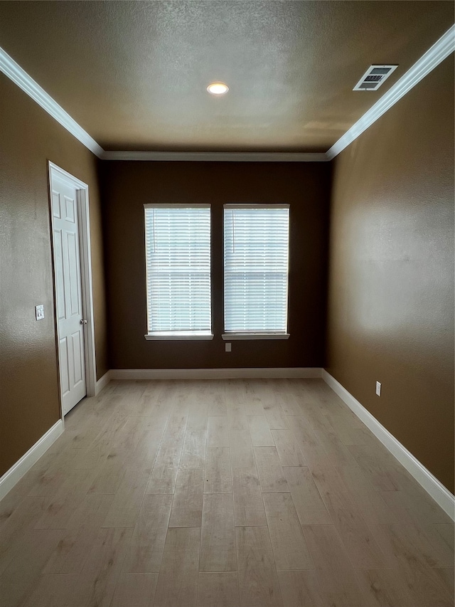 unfurnished room featuring ornamental molding, a textured ceiling, and light hardwood / wood-style flooring