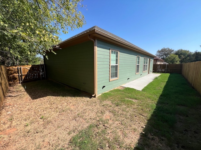 view of side of home with a yard