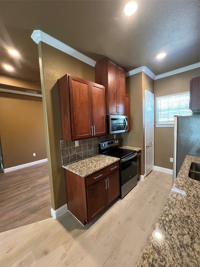 kitchen featuring light hardwood / wood-style floors, crown molding, decorative backsplash, light stone countertops, and appliances with stainless steel finishes