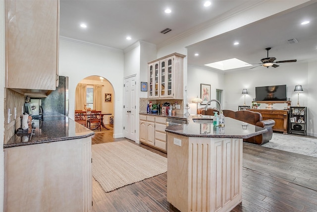 kitchen featuring backsplash, stainless steel refrigerator, ornamental molding, and hardwood / wood-style floors