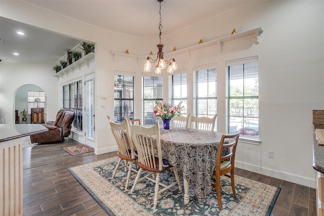 dining area featuring an inviting chandelier, crown molding, and dark hardwood / wood-style floors