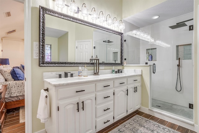 bathroom featuring vanity, an enclosed shower, and wood-type flooring