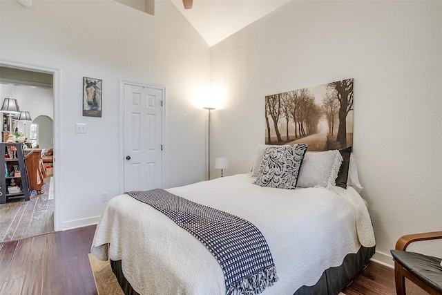 bedroom featuring high vaulted ceiling and dark hardwood / wood-style flooring