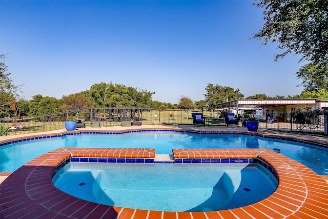 view of swimming pool featuring an in ground hot tub