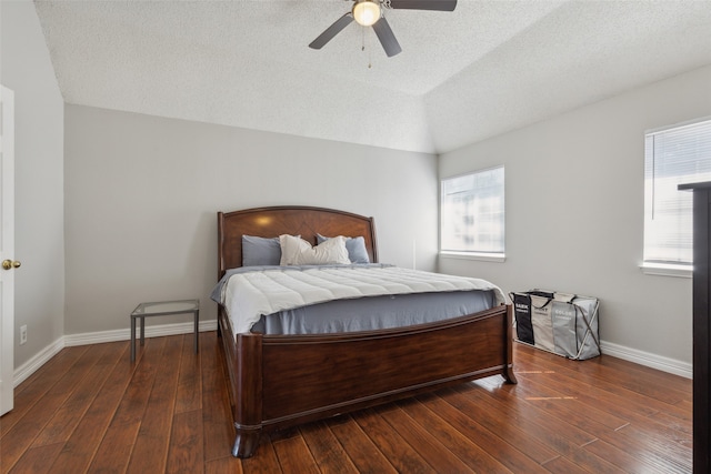 bedroom featuring dark wood-type flooring, ceiling fan, and a textured ceiling