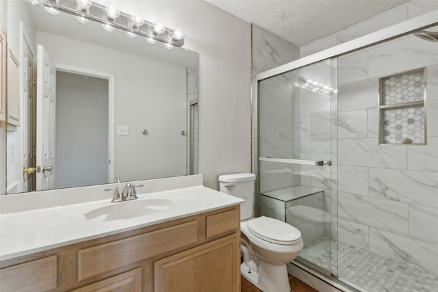 bathroom featuring vanity, a shower with shower door, a textured ceiling, and toilet