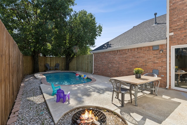 view of swimming pool featuring a patio and a fire pit