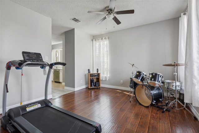 workout area featuring ceiling fan, a textured ceiling, and hardwood / wood-style floors