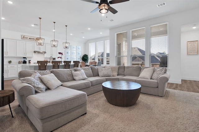 living room with wood-type flooring and ceiling fan