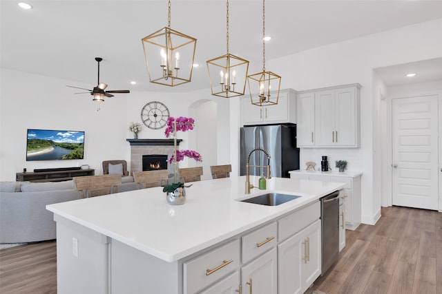 kitchen with a center island with sink, sink, appliances with stainless steel finishes, and white cabinetry