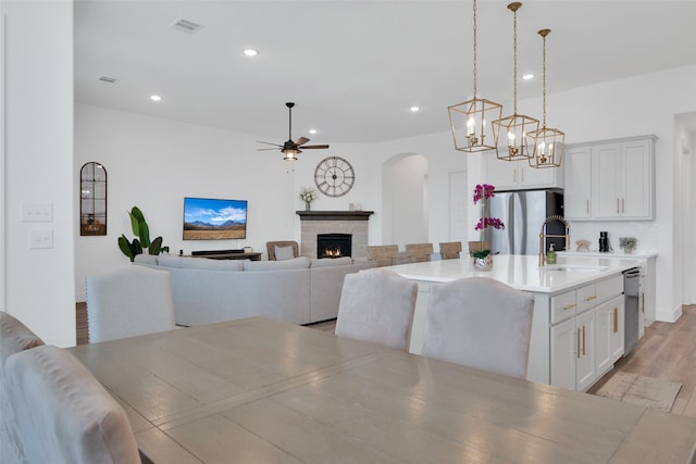 dining space featuring sink, light hardwood / wood-style flooring, and ceiling fan