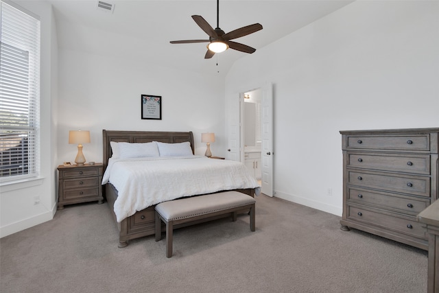 carpeted bedroom with lofted ceiling, ceiling fan, and ensuite bath