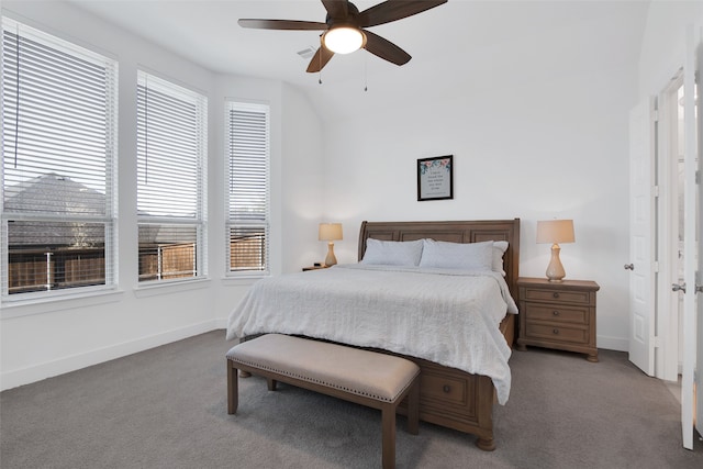 carpeted bedroom with ceiling fan, vaulted ceiling, and multiple windows