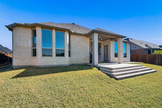 back of property with a yard and a patio